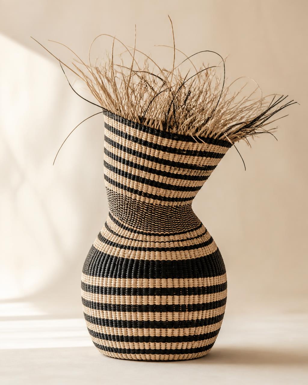 Sculptural handwoven elephant grass basket presented as collectible fibre art